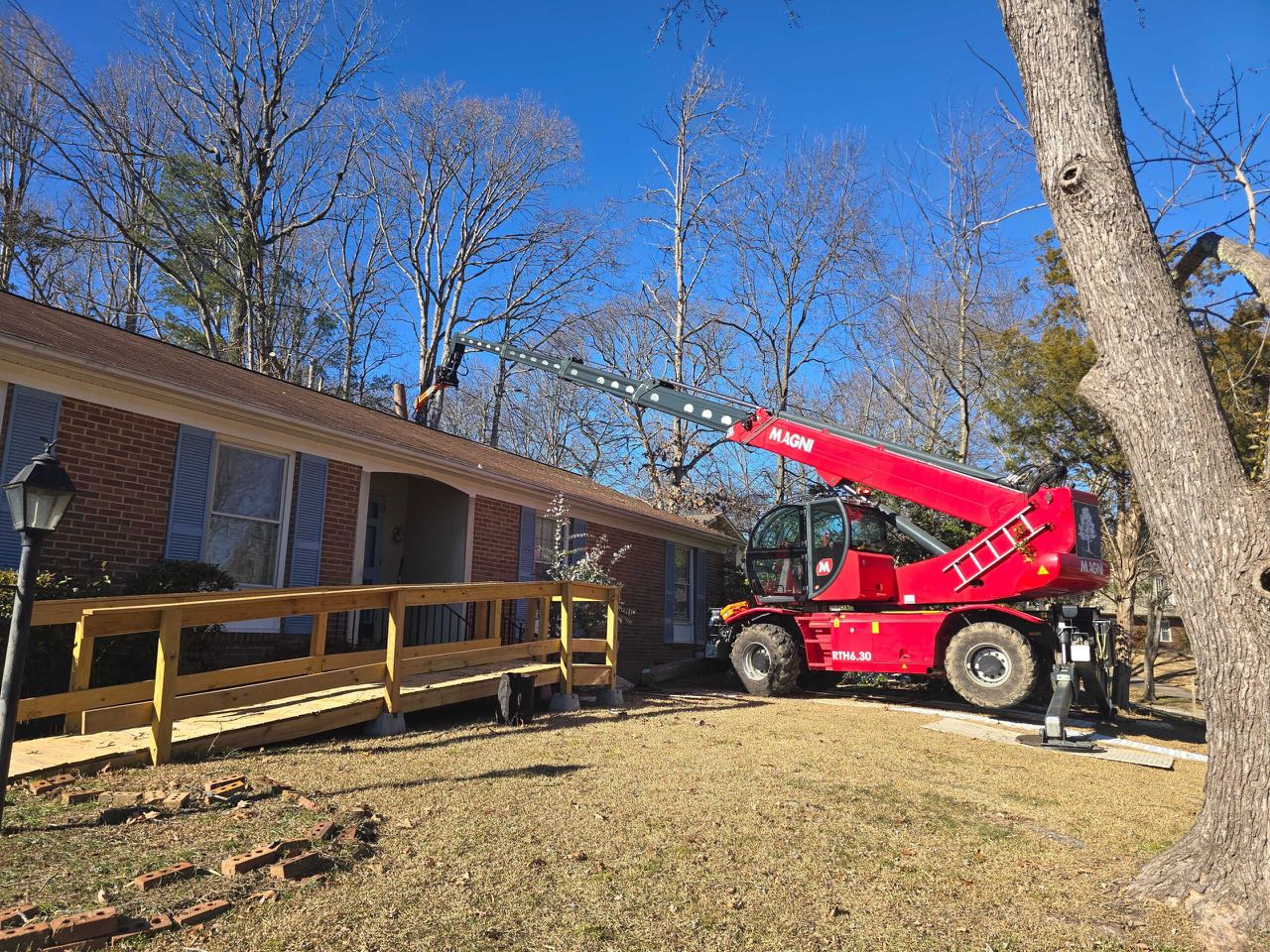 Tree Removal — Telehandler Removal Beside a Home